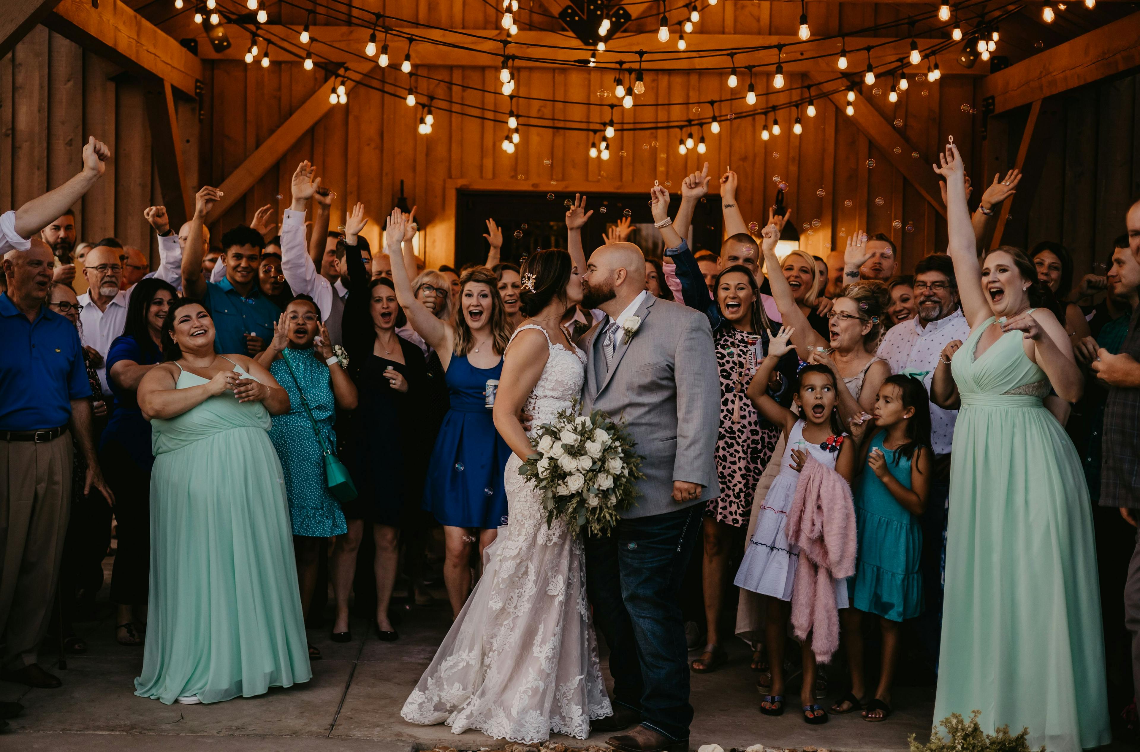 bride, groom, kiss, cheer, family, friends, barn, wedding